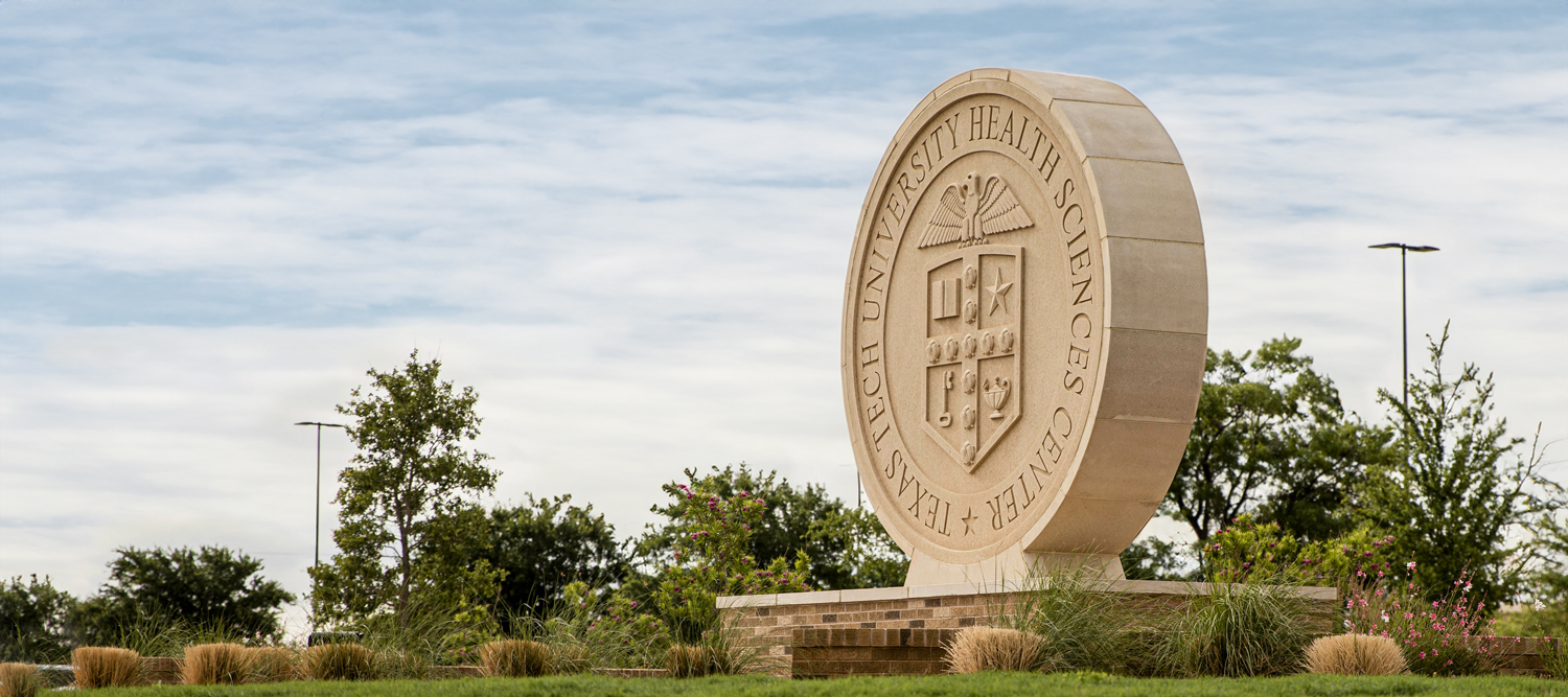 TTUHSC seal statue surrounded by greenery