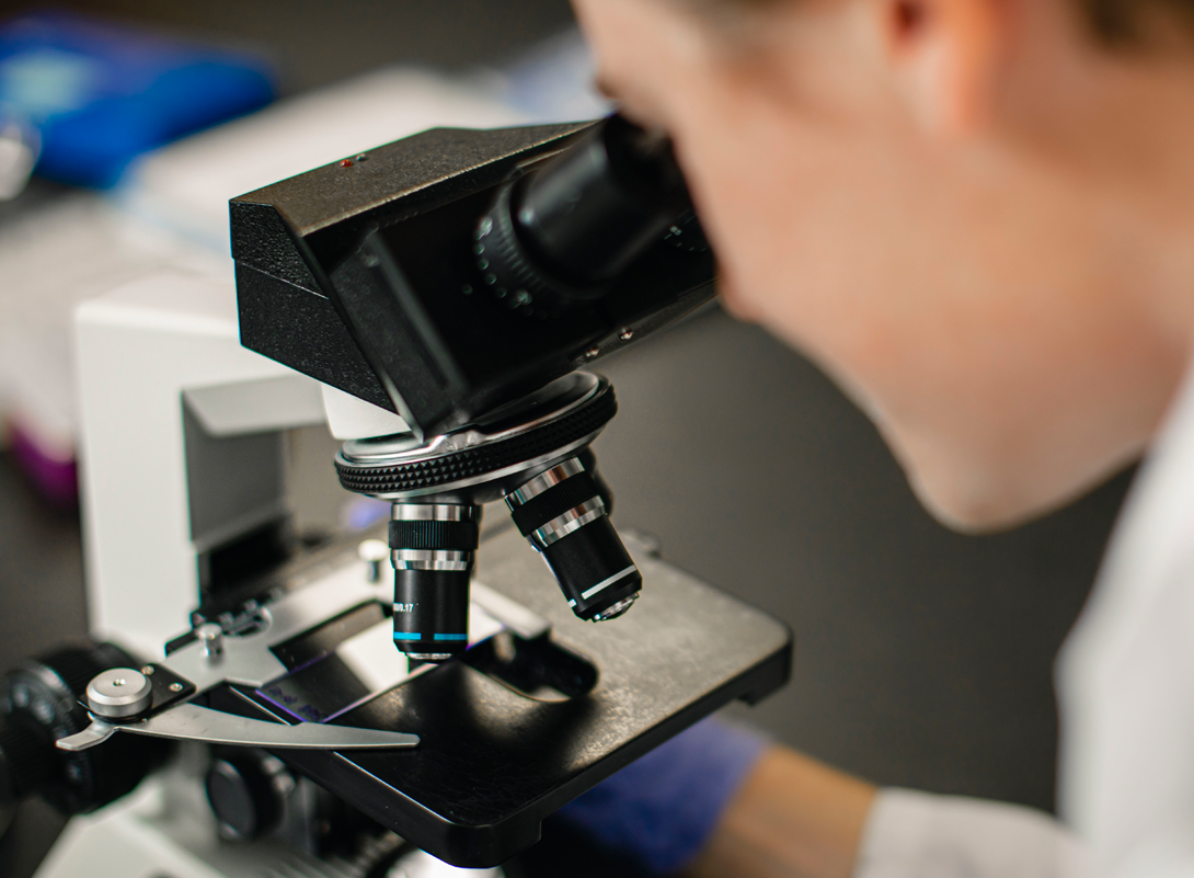 researcher at a microscope