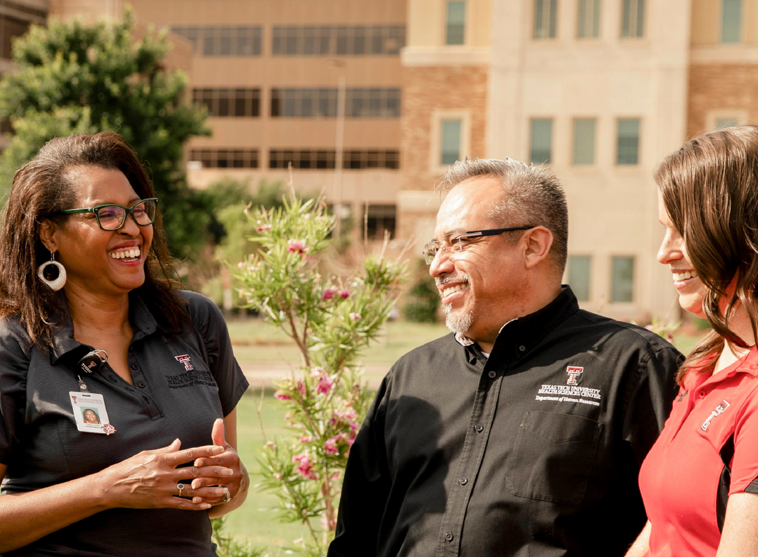 two ladies and a man that are collegues visiting outside on TTUHSC campus