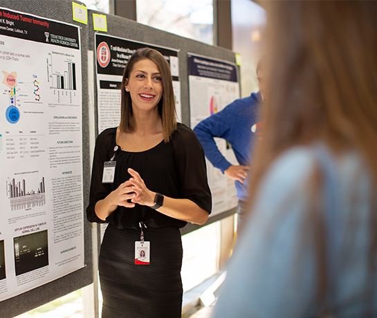 ttuhsc biomedical student standing presenting a research to a woman smiling