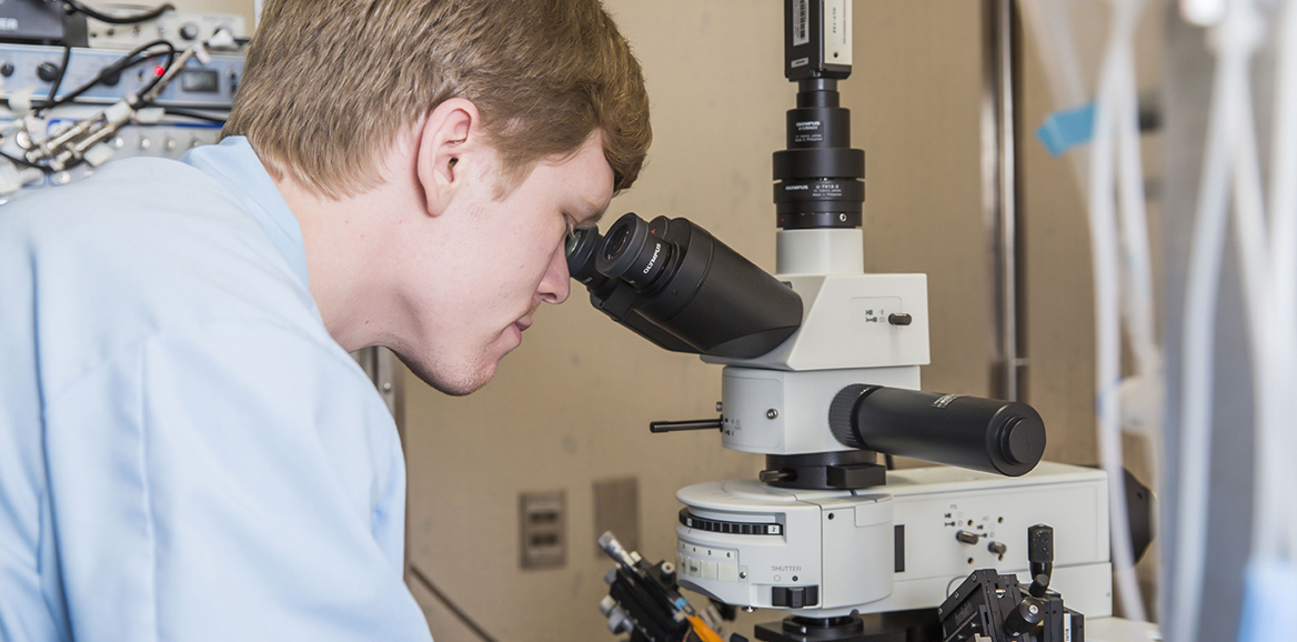 man looking in microscope