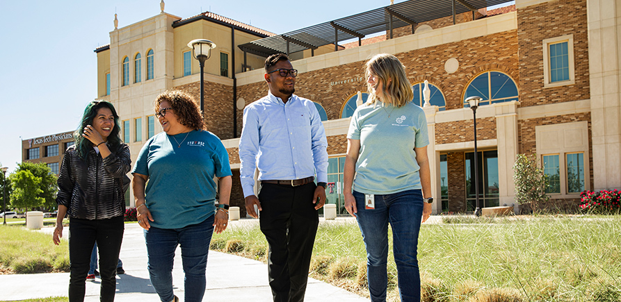 Group of TTUHSC staff walking infront of the Academic Center