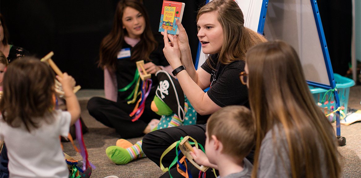Speech students interact with toddlers during a session