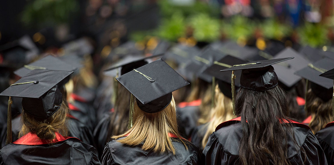 A sea of graduates in their regalia waiting sitting during the commencement ceremony 