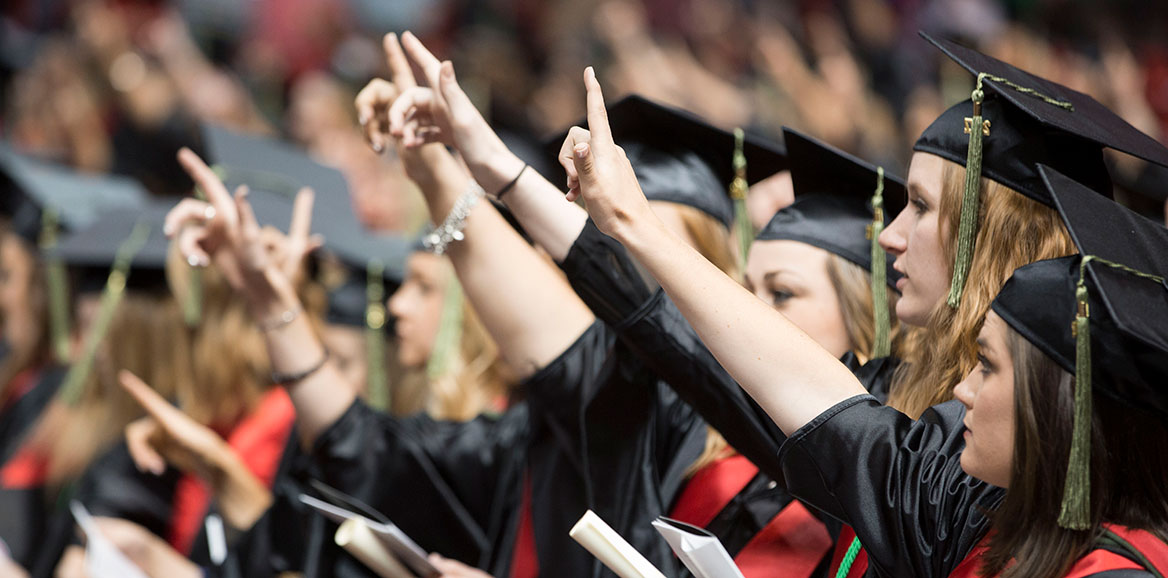 Students raise their "Guns Up" during The Matador Song at the end of commencement