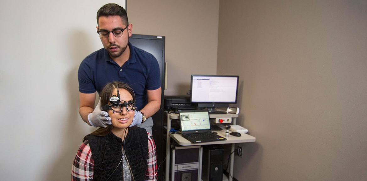 Audiology student works with a patient to perform an exam