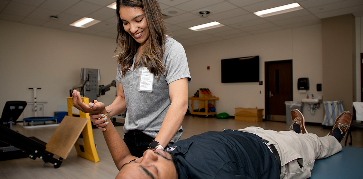 Physical Therapy student performs an exercise on another student