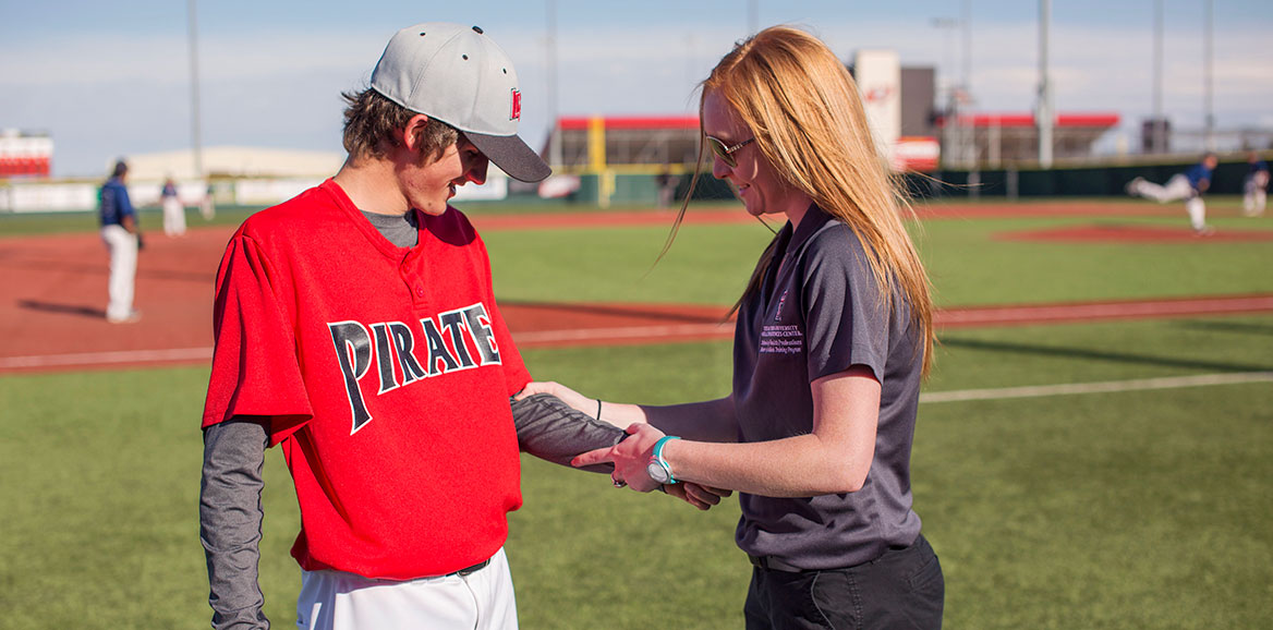 A TTUHSC MAT student evaluates a high school baseball player's arm.