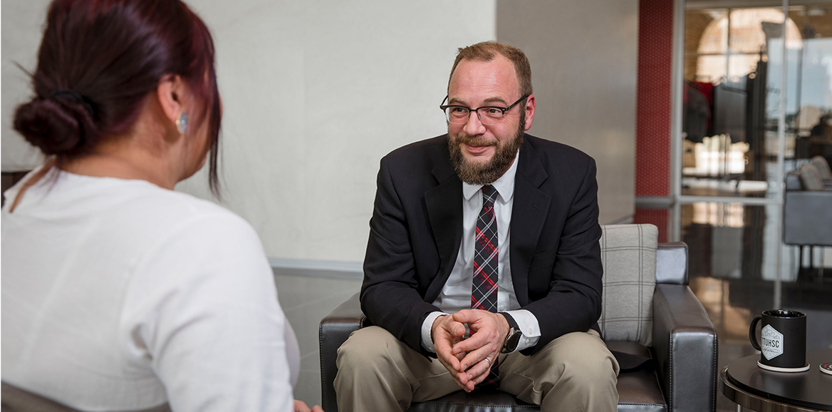 Instructor sitting down speaking to a student