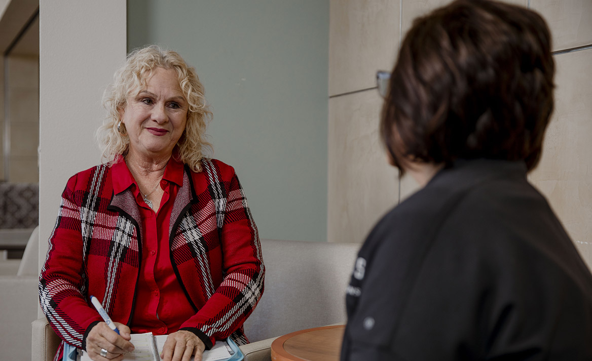 A counselor sits and has a conversation with another person