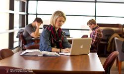 TTUHSC student on laptop in the library