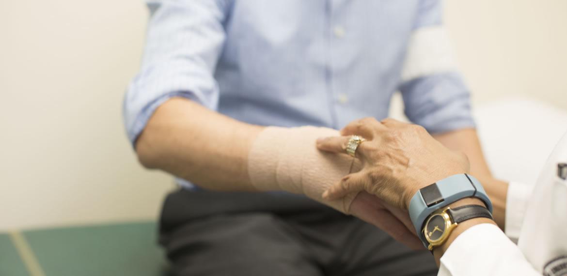 Man with hurt wrist receiving care Man with hurt wrist receiving care