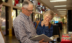 Stephen Walling, MD, (Medicine '76) looks at old yearbooks with his wife, Sharon. 