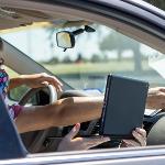 Passenger holding laptop inside car