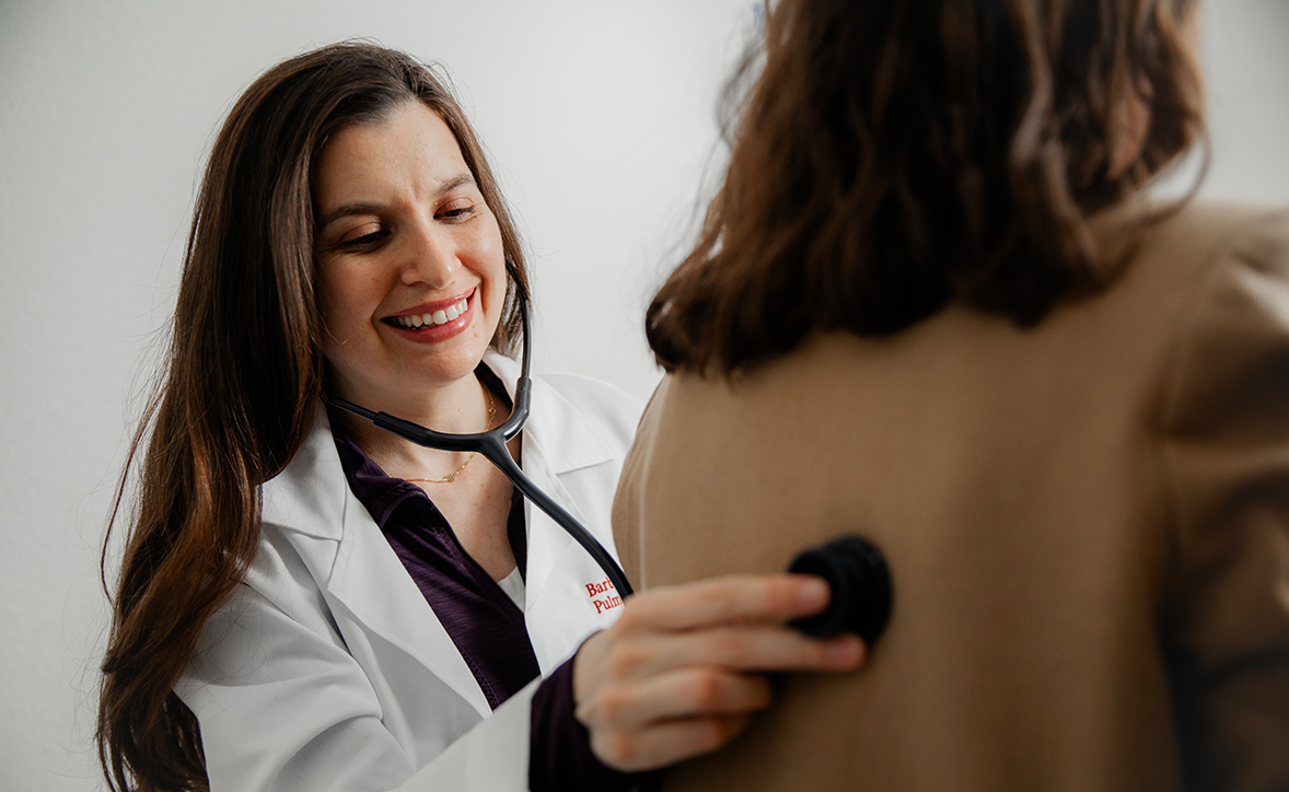 graphic image of fellow using stethoscope on patient