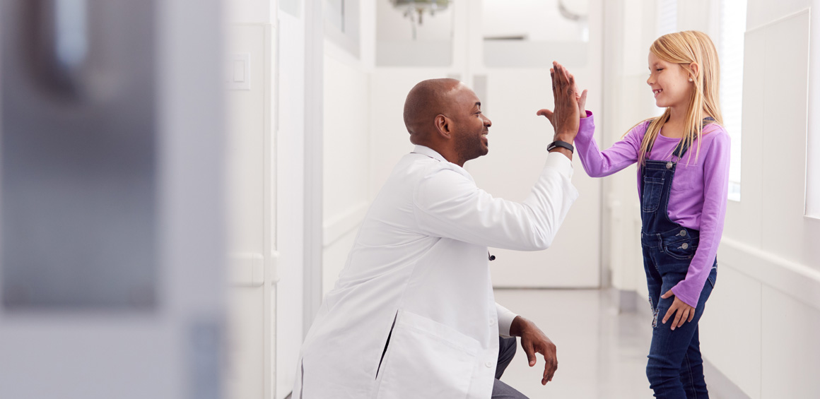 primary care doctor giving a high-five to a young girl