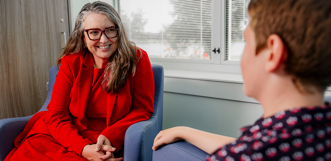 TTUHSC fellow sitting in a chair smiling with a patient sitting in a chair
