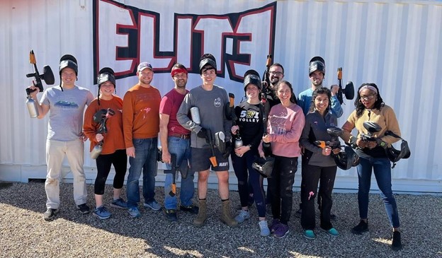 Surgery residents in painball gear standing infront of a metal wall