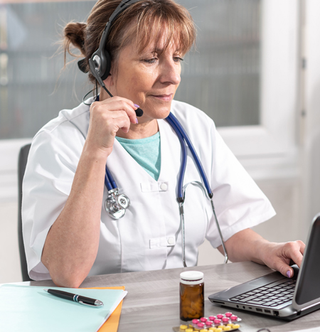 Provider on telehealth visit via headset and computer monitor with camera