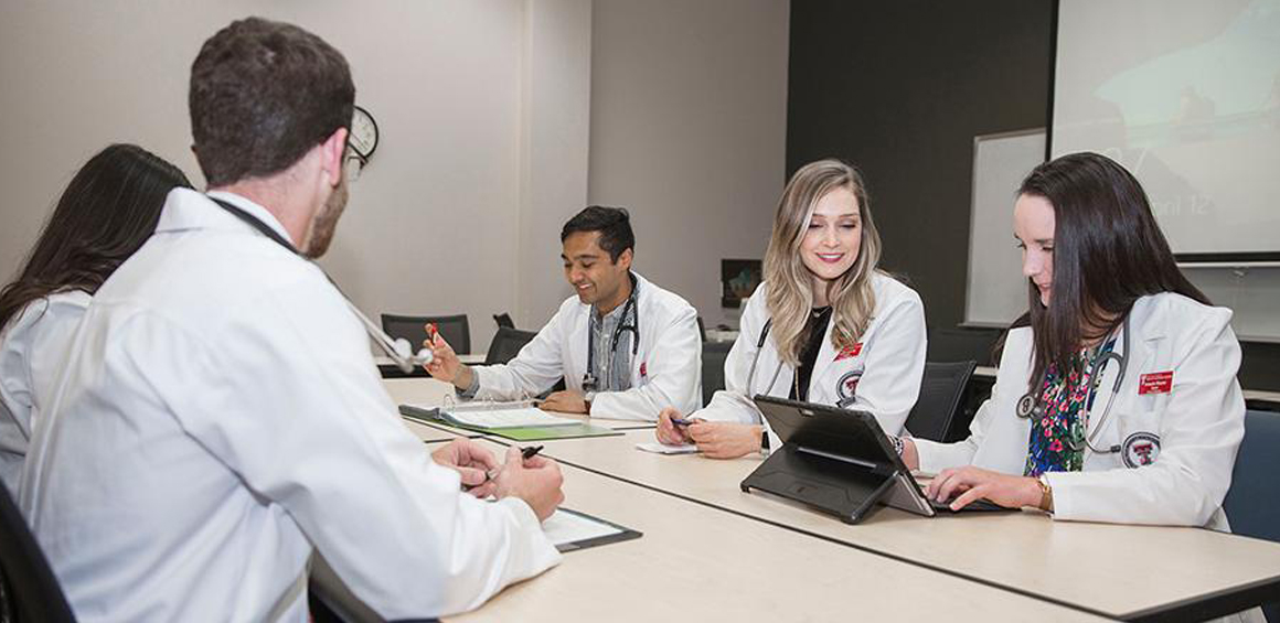 TTUHSC residents at a table in group discussion.