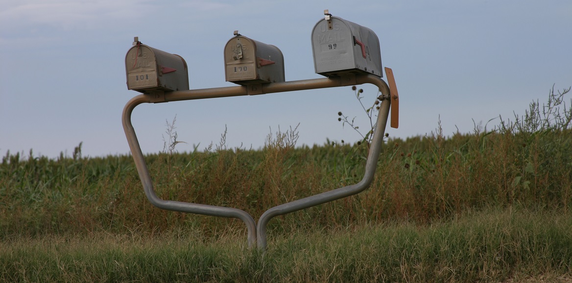 Three mailboxes in front of a field