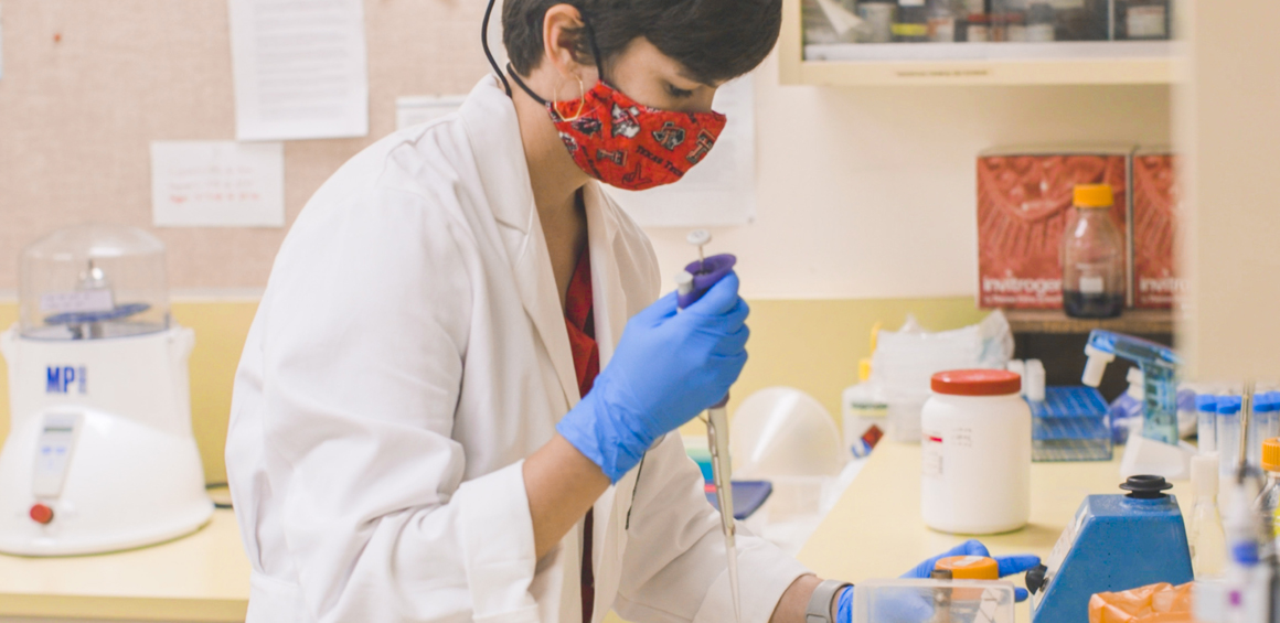 team member in research lab with mask