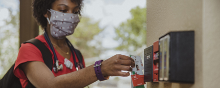 student scanning her badge for access