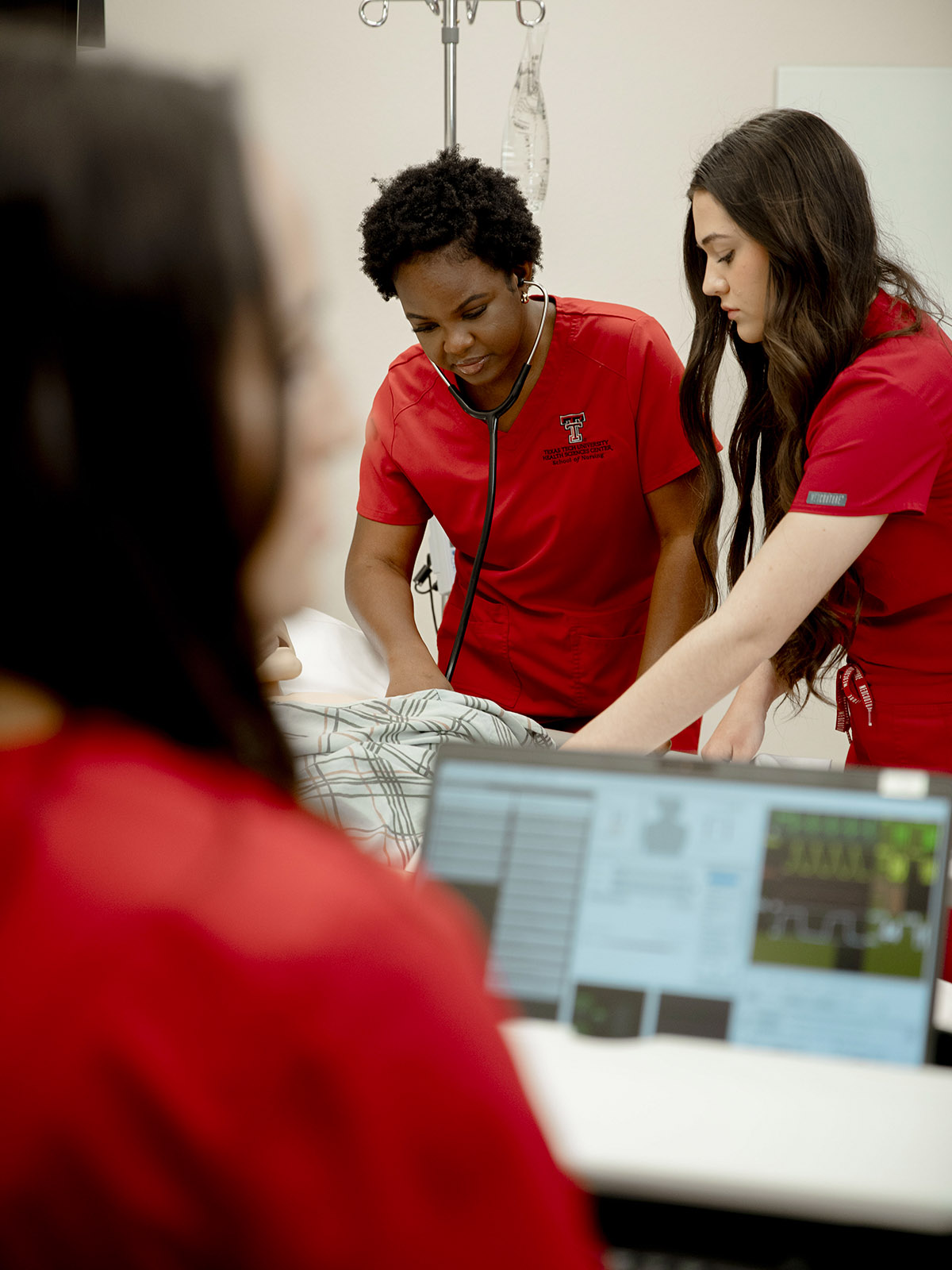 TTUHSC Amarillo nursing students in a simulation room with a mannequin while using a stethescope.