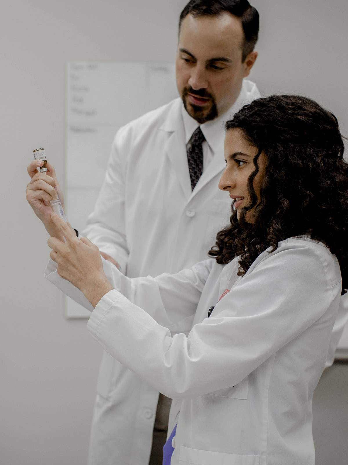TTUHSC Amarillo instructor and student inserting needle syringe in medication bottle.