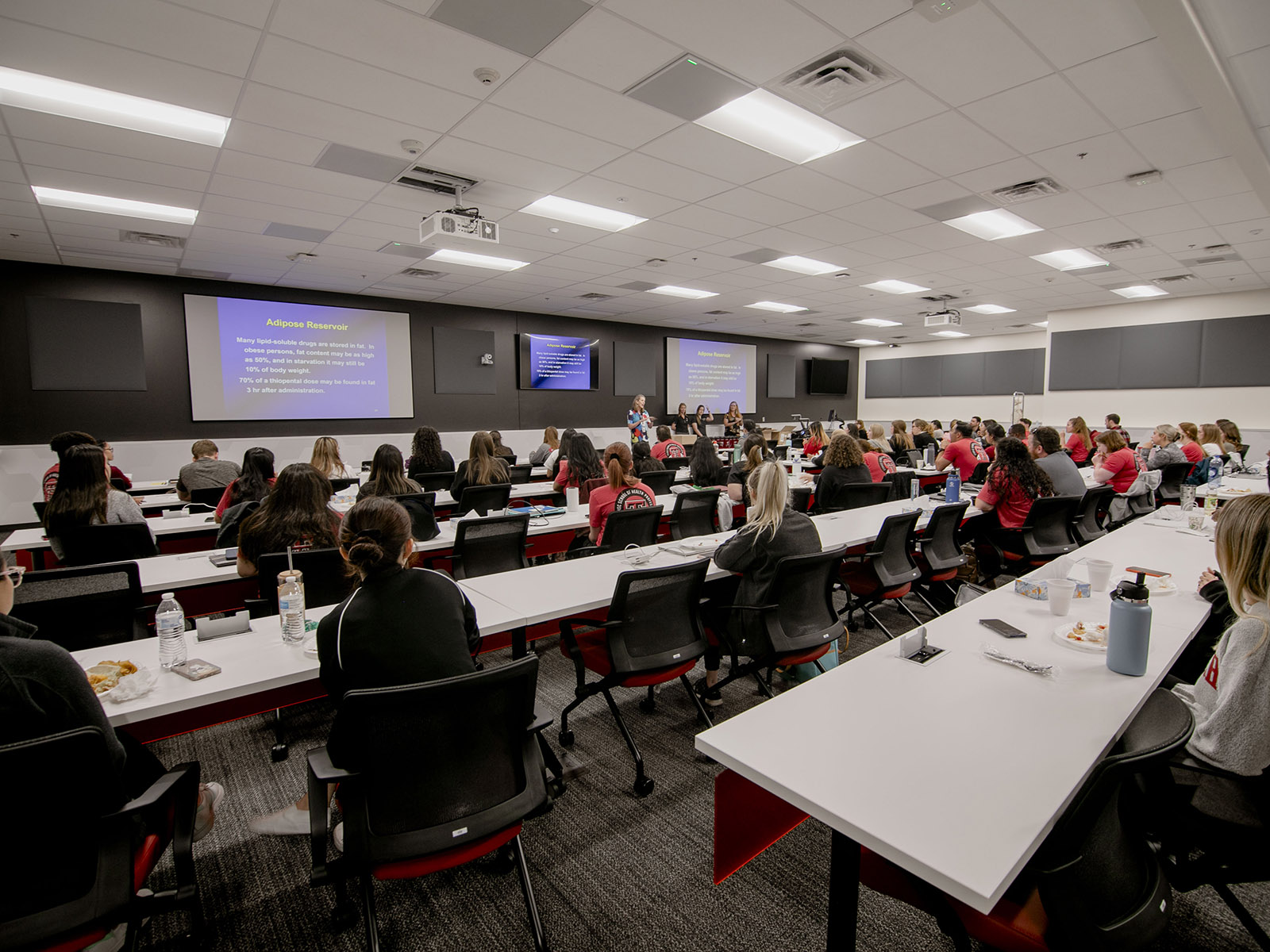 TTUHSC Midland PA students in a large classroom with instructors at the front giving presentations
