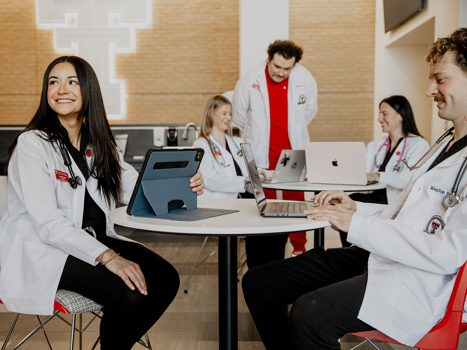 TTUHSC PA students in white coats and laptops sitting at tables