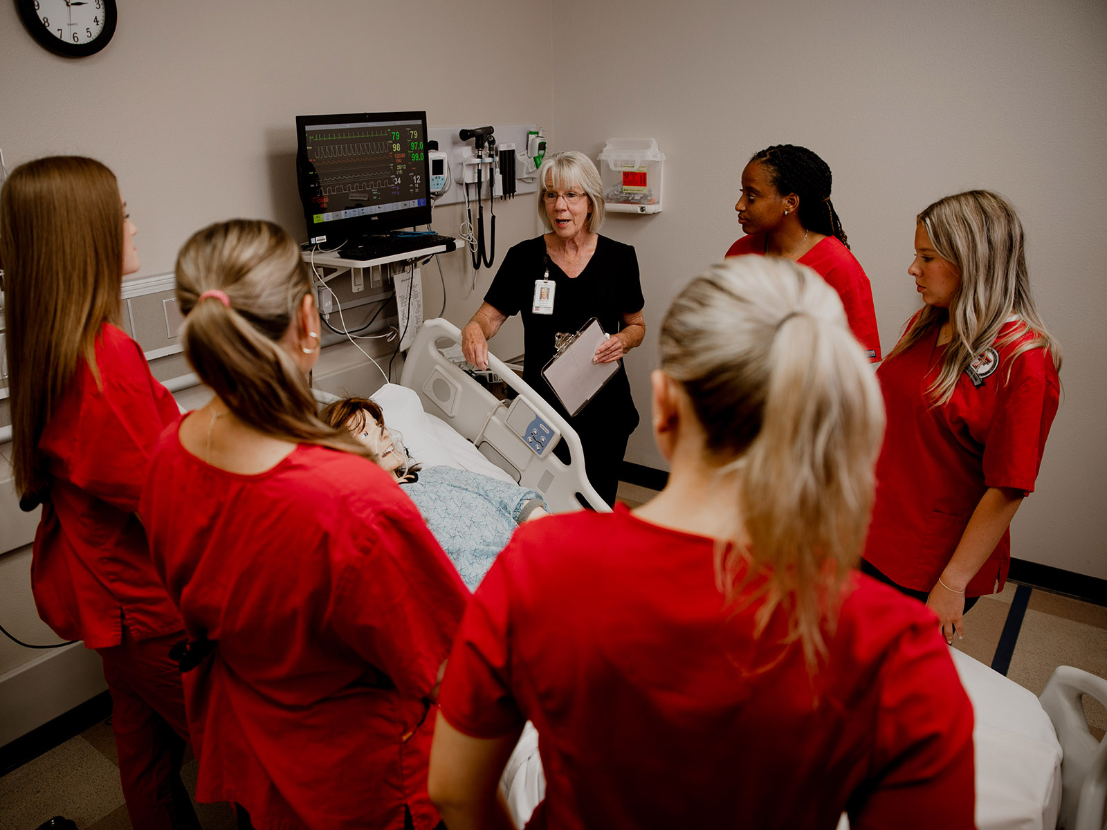 TTUHSC Abilene students standing with instructor around a patient bedside simulation.