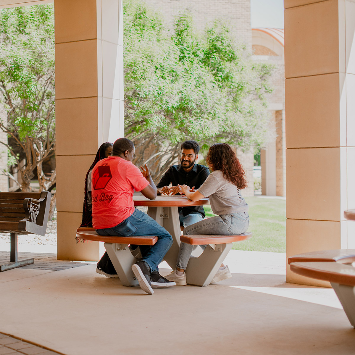 Four students at TTUHSC Abilene sitting at a picnic table talking
