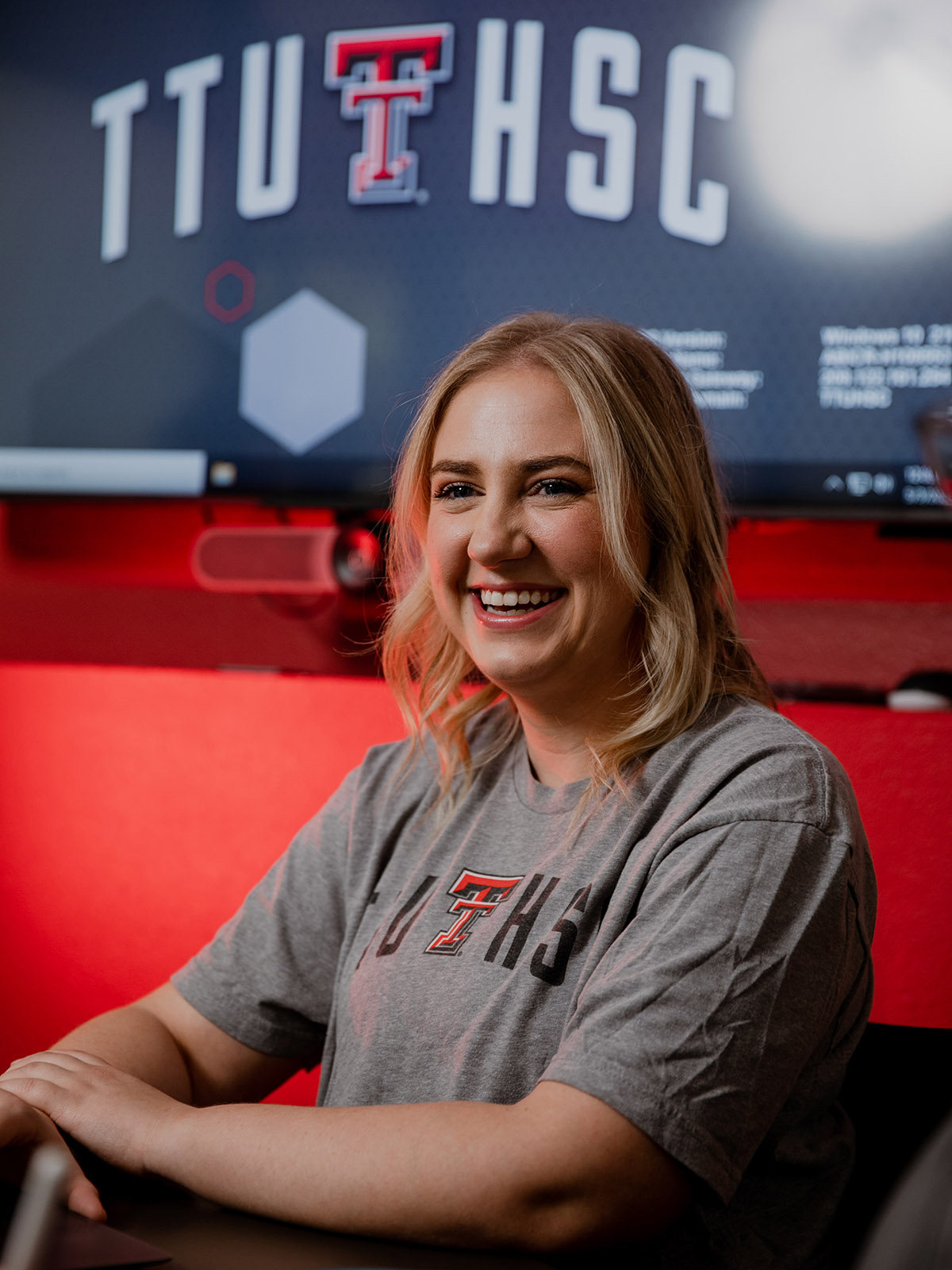 TTUHSC Abilene student smiling in a classroom with a projector screen in the background.