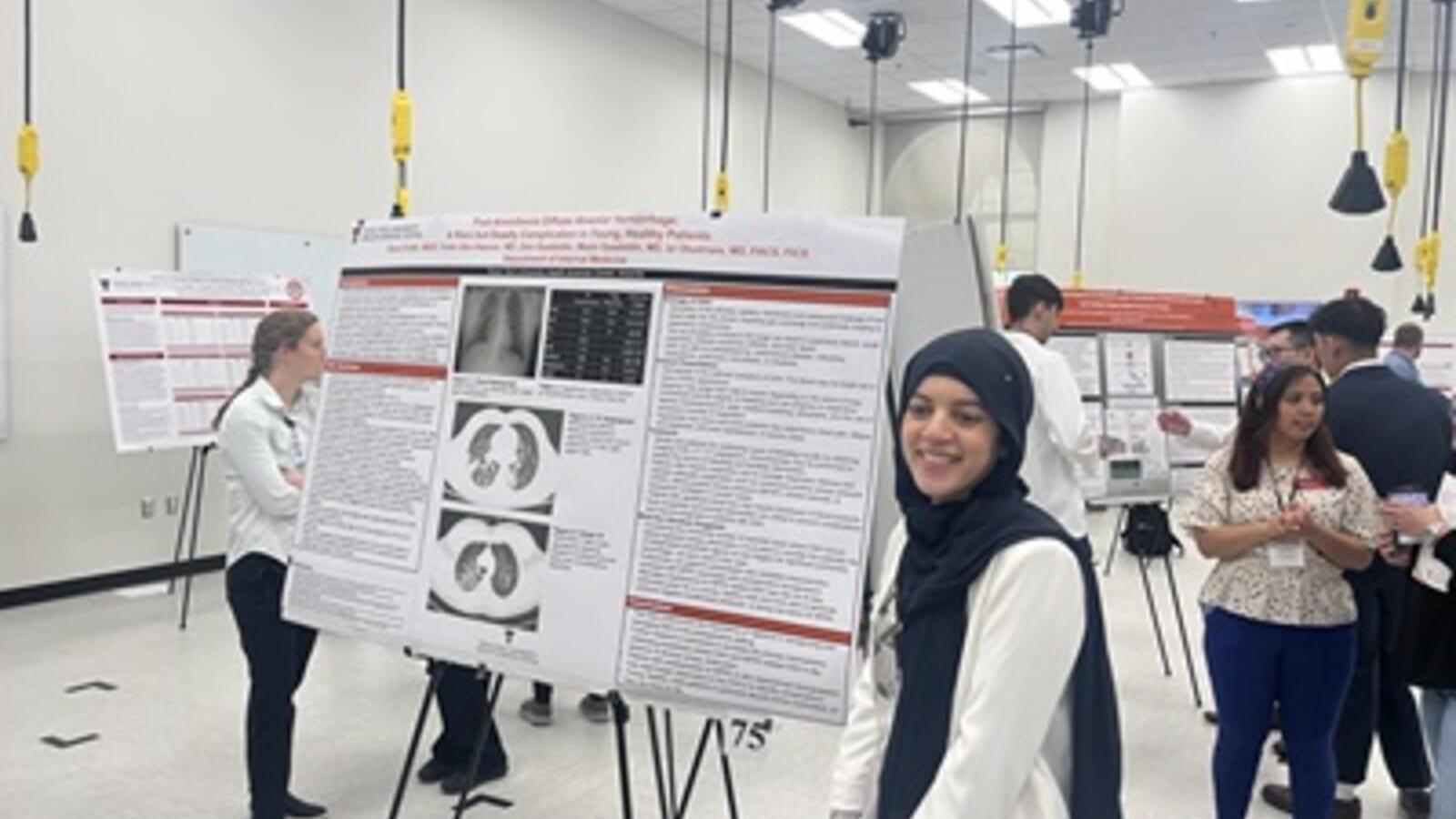 woman standing in front of a research presentation poster board