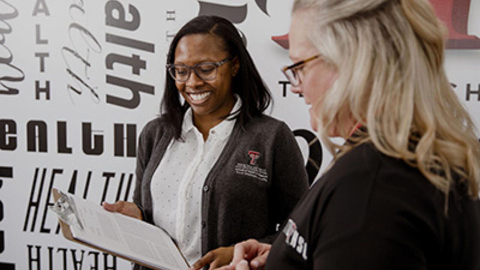 Two health care professionals working together, looking at a clipboard