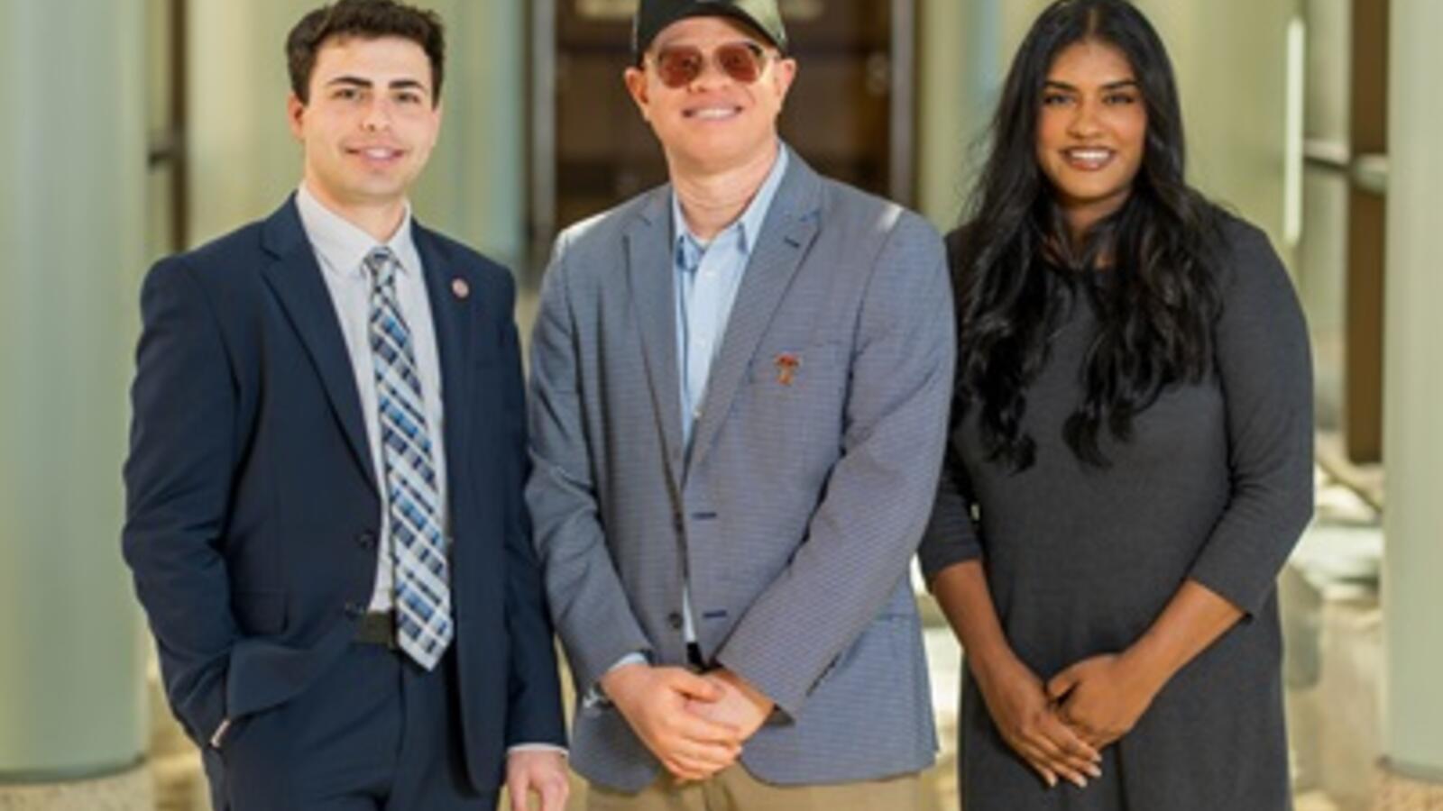 Three people take a group photo