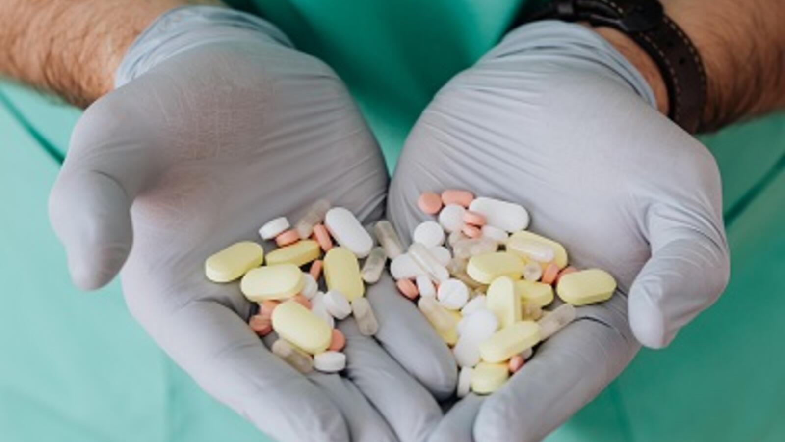 hands holding an assortment of medication