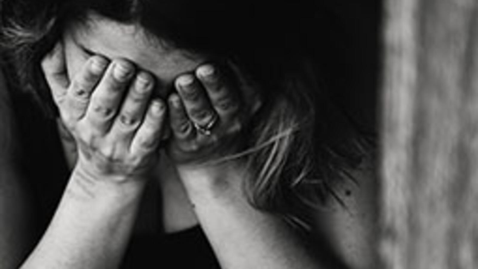 black and white photo of woman with face in hands