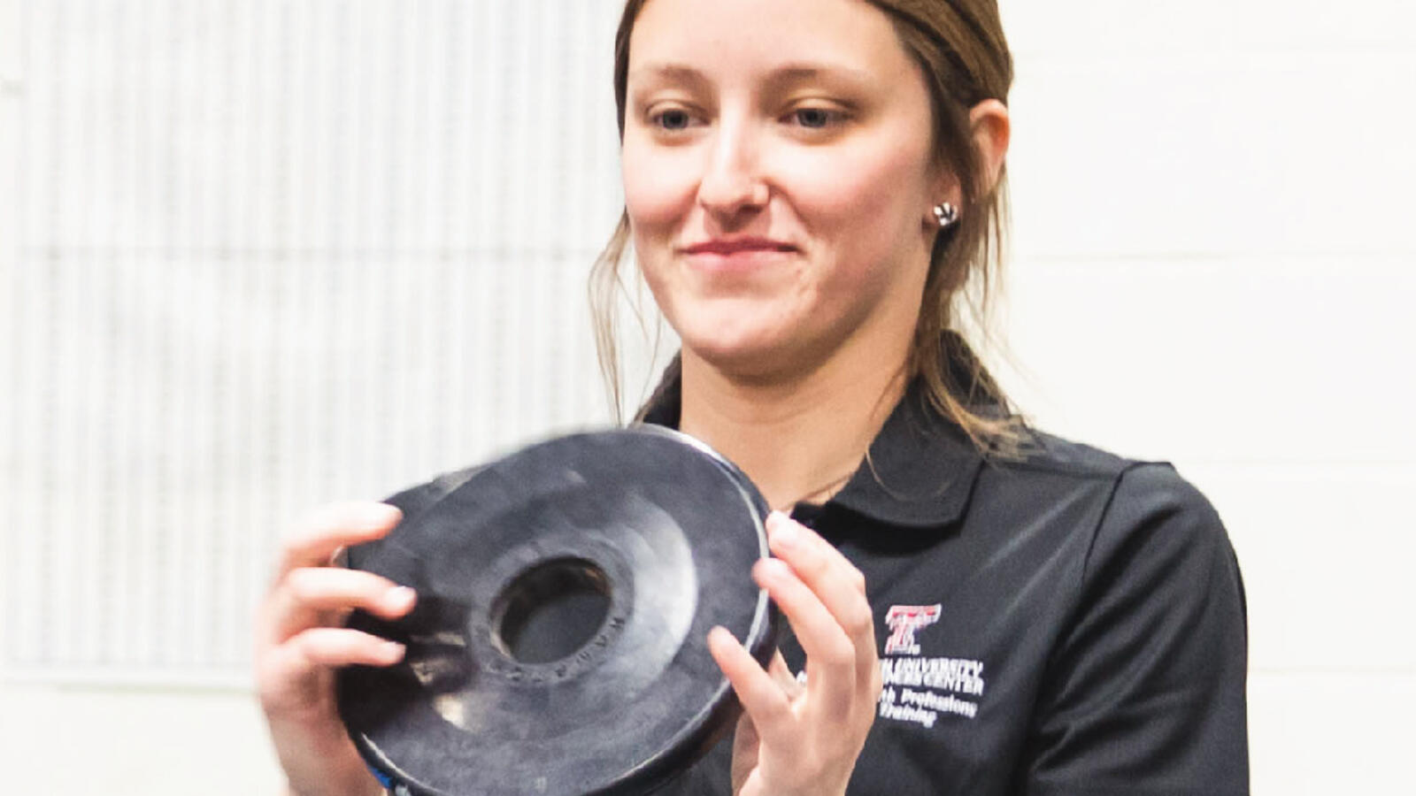 TTUHSC Athletic Training student working with a patient using weights.
