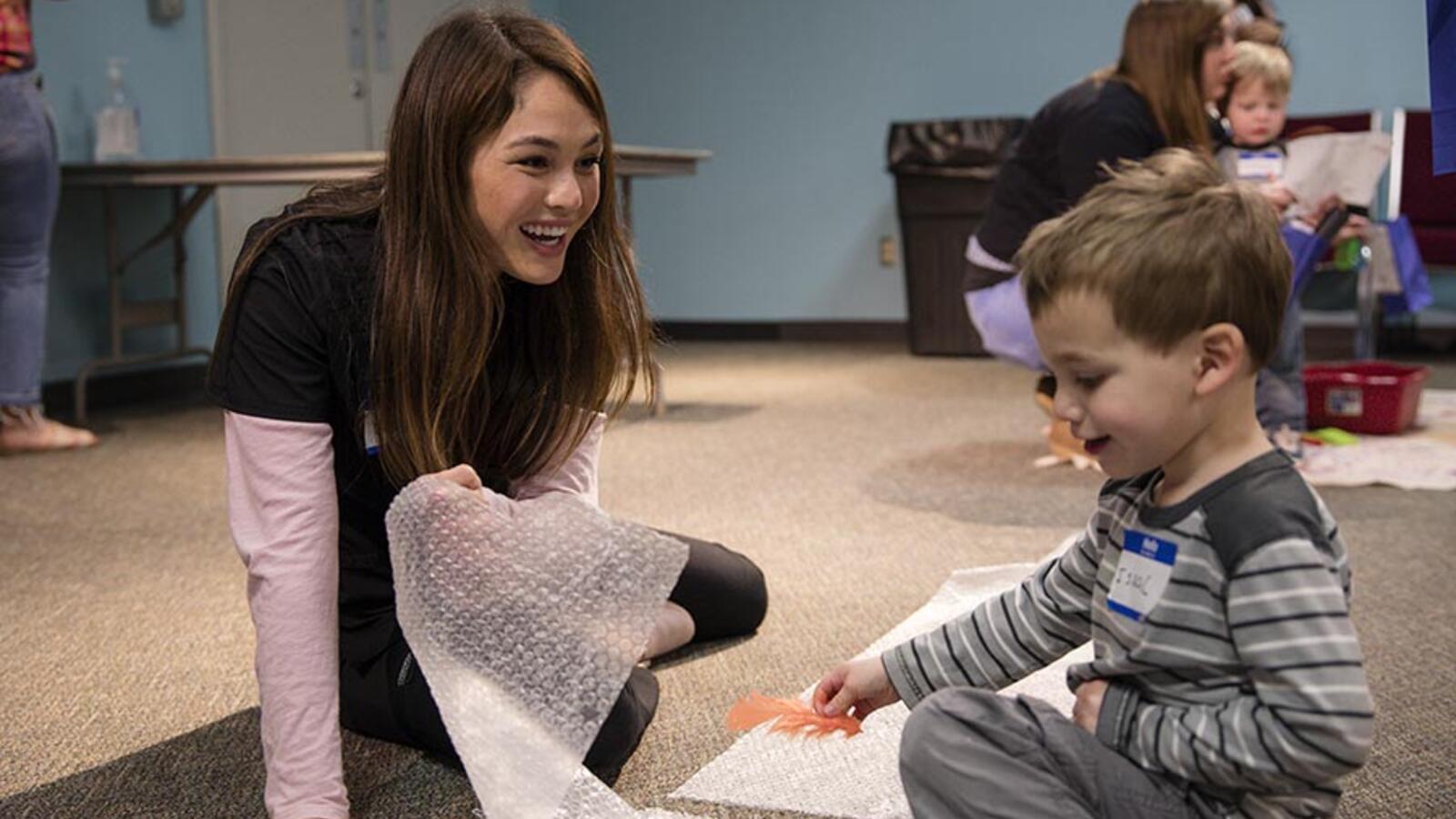 woman playing with child in health care environment