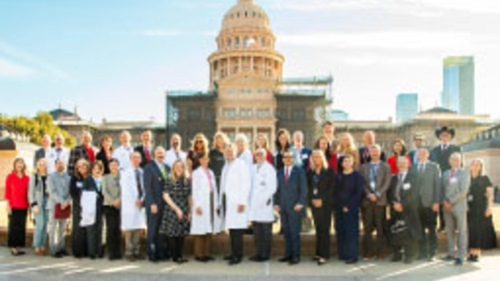 Large group TTUHSC faculty and staff stand in front of the State Capitol of Texas building.