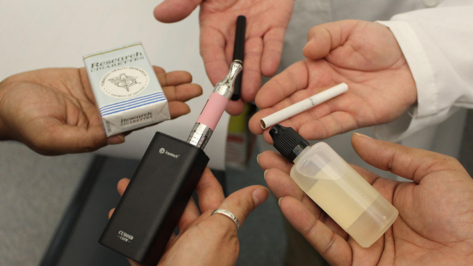 laboratory assistants holding smoking devices
