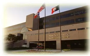 A brown building with two flags in front of it.