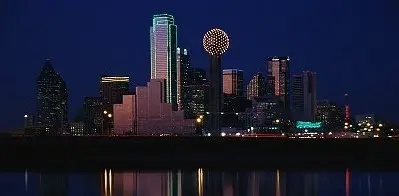 Dallas skyline illuminated at night across the Trinity River.
