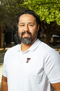 Headshot of Richard Ledesma wearing a white Texas Tech polo shirt, smiling outdoors.