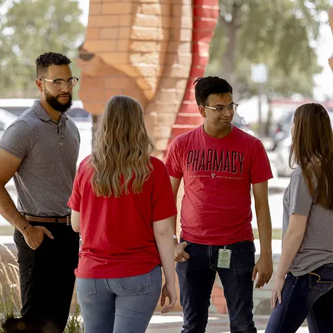 Pharmacy students talking outside the TTUHSC Amarillo campus.