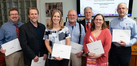 Faculty members and colleagues gather for a recognition presentation at Texas Tech University Health Sciences Center.