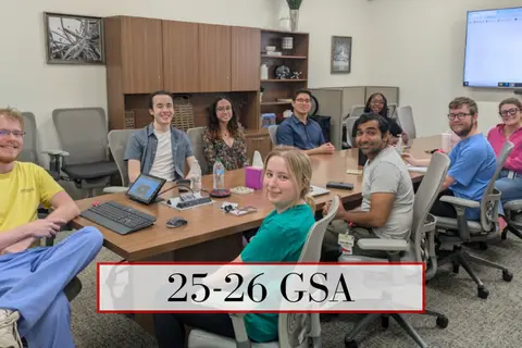 GSA students and faculty gather around a conference table.