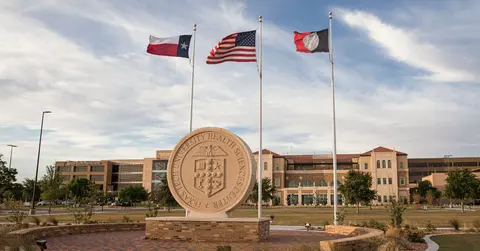 Texas Tech University Health Sciences Center seal and flags outside the Lubbock campus.